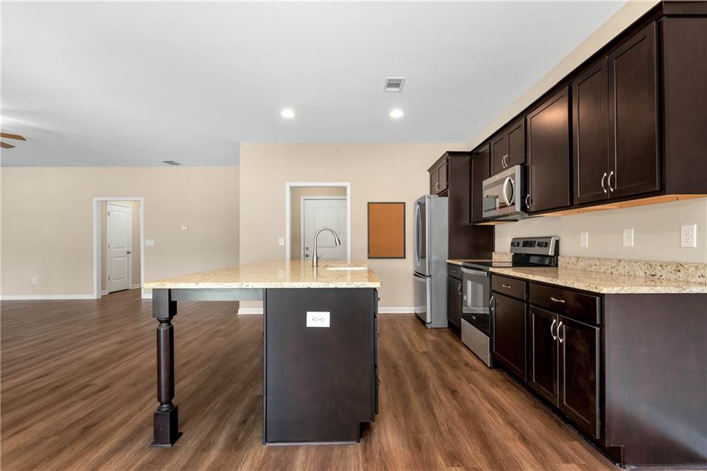 489 Asbury Mill Road Cleveland, GA 30528 - Photo 20 of 34 a kitchen with stainless steel appliances granite countertop a stove a sink and a refrigerator