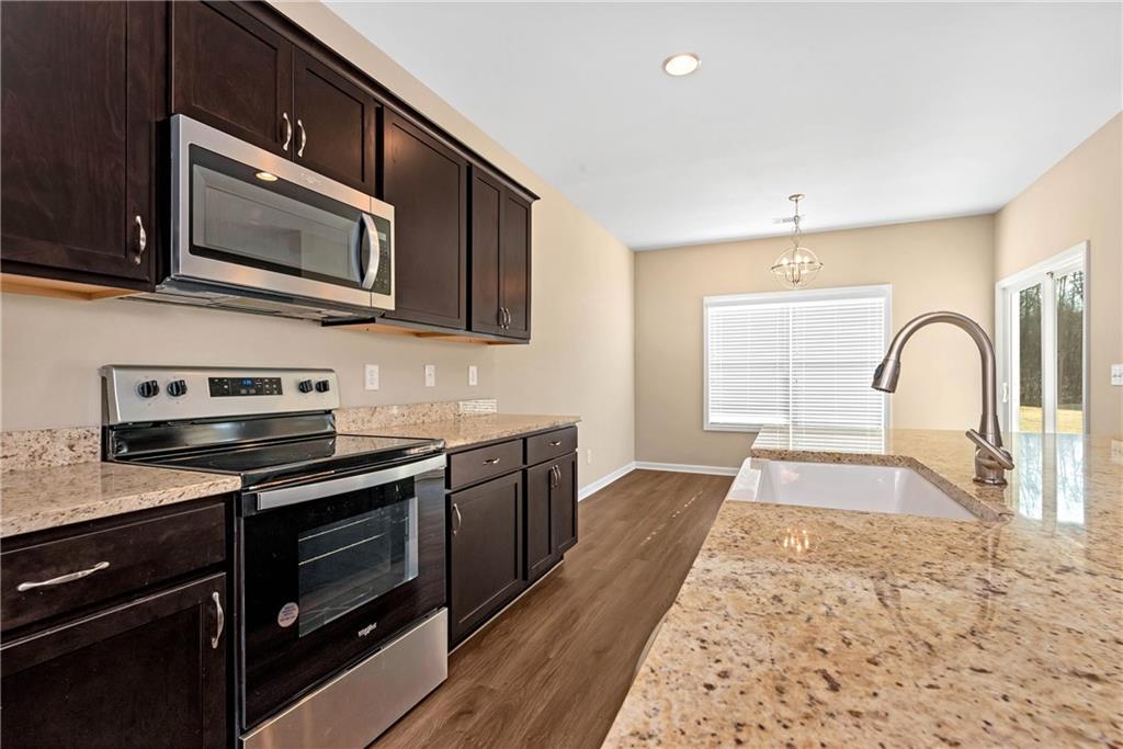 489 Asbury Mill Road Cleveland, GA 30528 - Photo 24 of 34 a kitchen with stainless steel appliances granite countertop a stove microwave and sink
