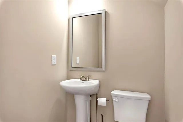 a bathroom with a sink toilet and a mirror