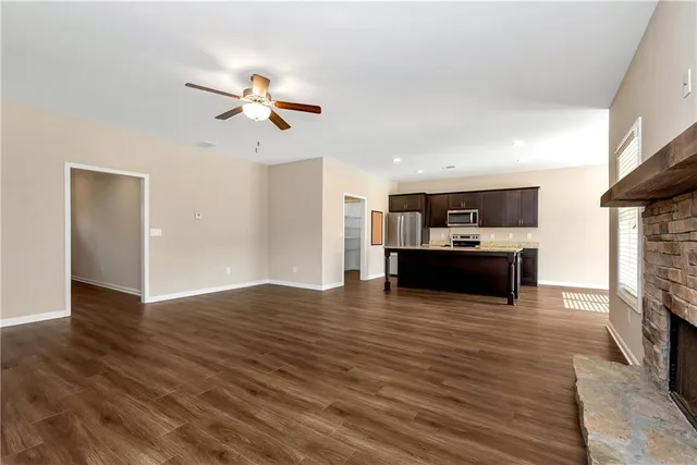 a view of kitchen with microwave a stove a refrigerator cabinets and wooden floor