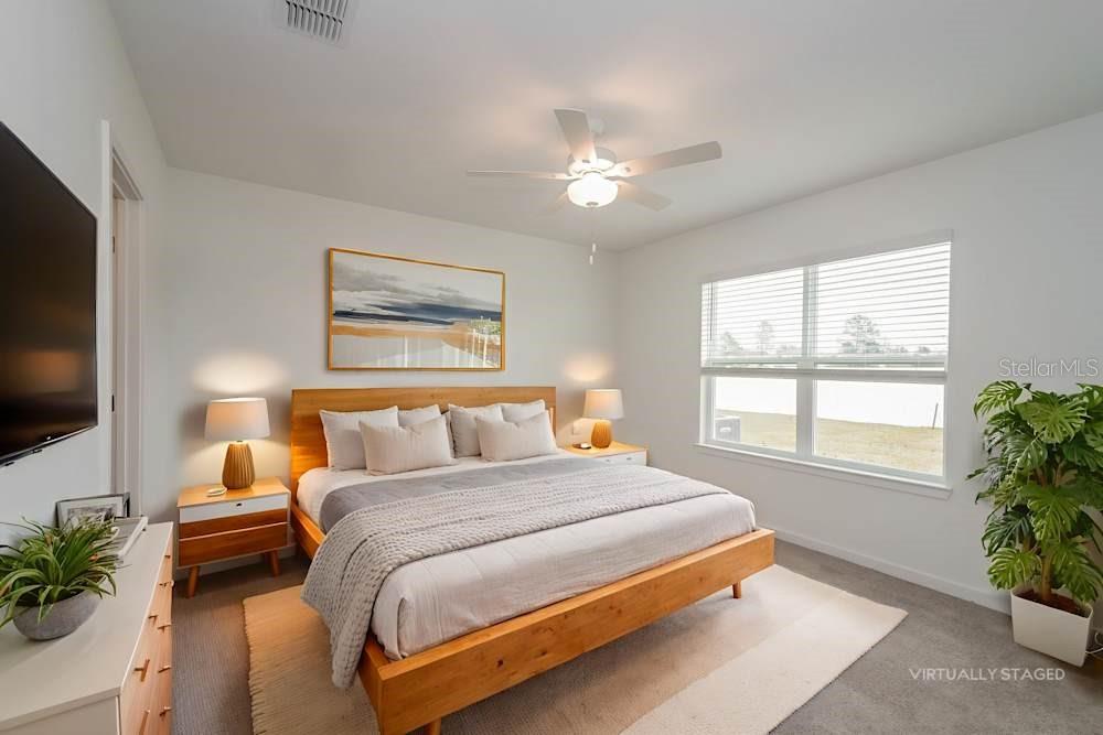 3650 Benham Rise Road Spring Hill, FL 34609 - Photo 6 of 7 a bedroom with a large bed and a flat tv screen on dresser