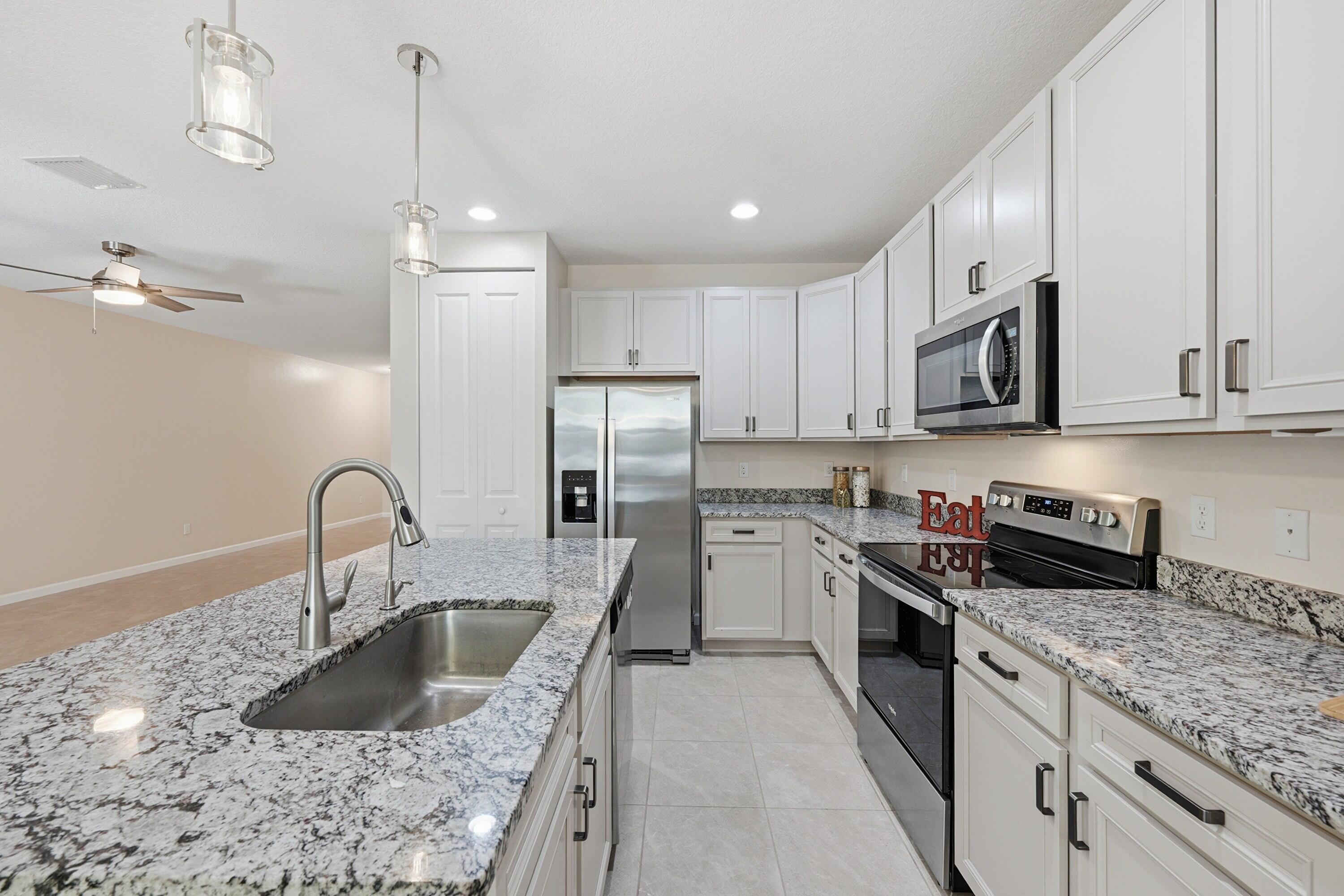 340 Northwest 33rd Lane Pompano Beach, FL 33069 - Photo 11 of 47 a kitchen with stainless steel appliances granite countertop a sink a stove and a refrigerator
