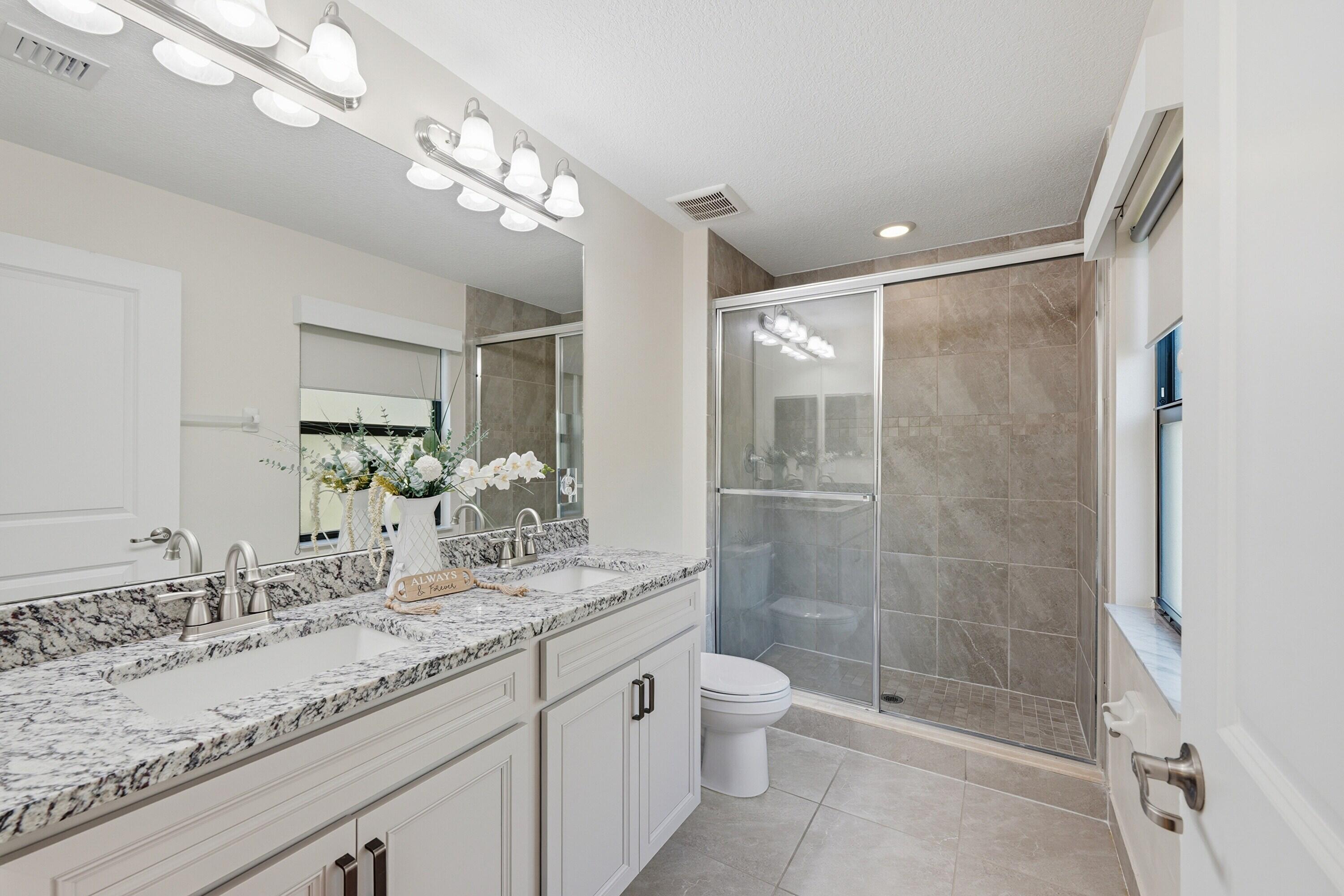 340 Northwest 33rd Lane Pompano Beach, FL 33069 - Photo 20 of 47 a bathroom with a granite countertop sink a toilet a large mirror and shower