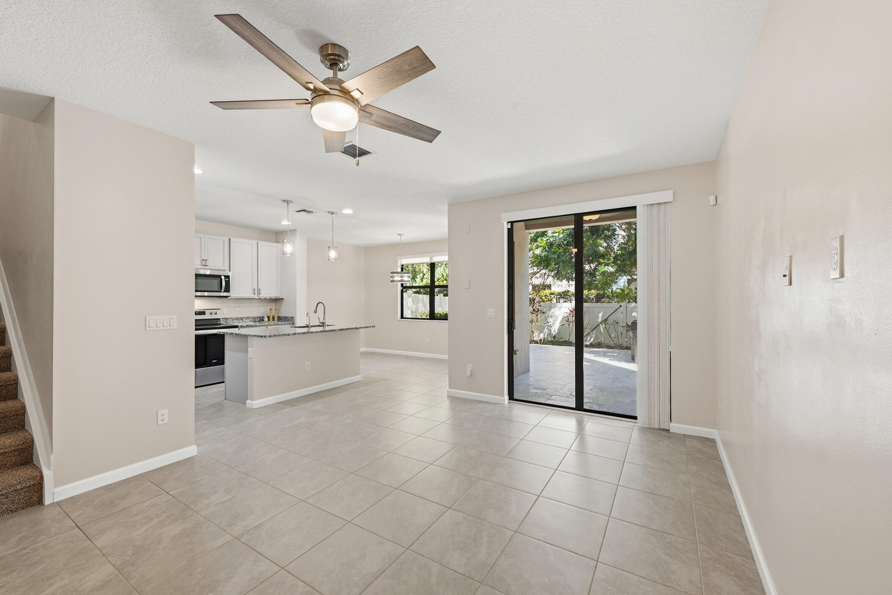 340 Northwest 33rd Lane Pompano Beach, FL 33069 - Photo 5 of 47 a view of a kitchen with kitchen island wooden floor and a ceiling fan