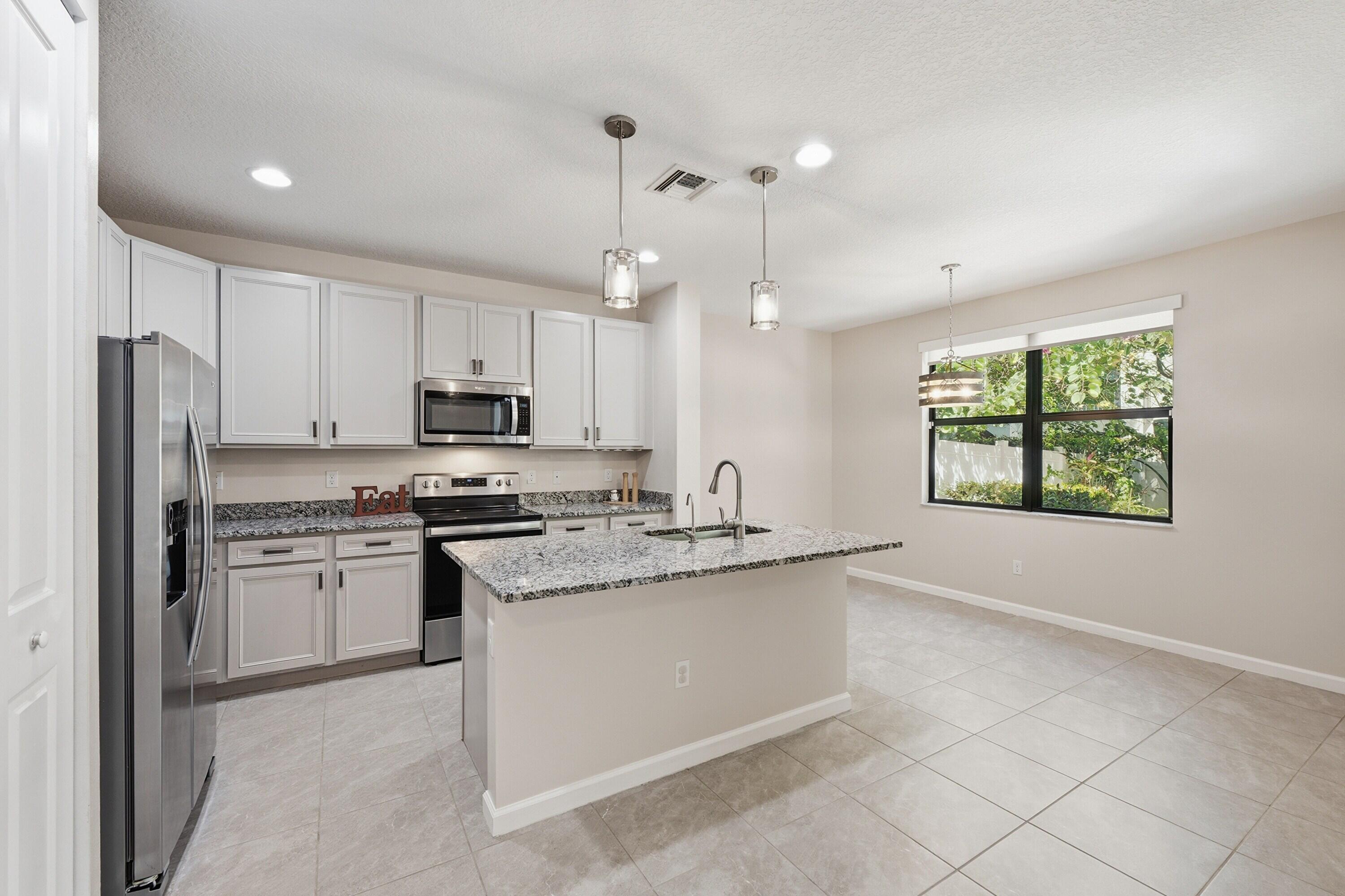 340 Northwest 33rd Lane Pompano Beach, FL 33069 - Photo 8 of 47 a kitchen with stainless steel appliances granite countertop a stove a sink dishwasher a refrigerator and a oven with wooden floor