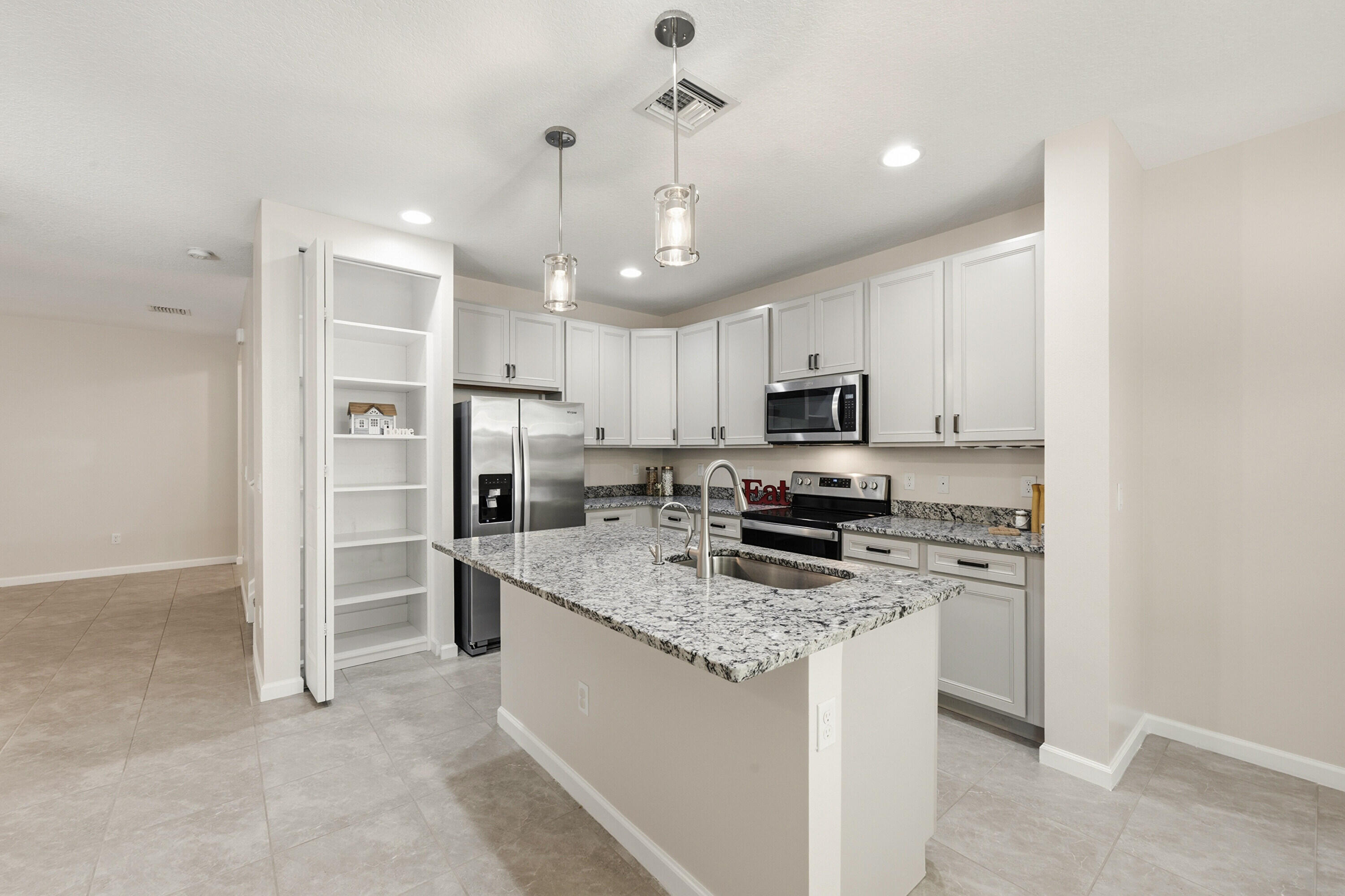 340 Northwest 33rd Lane Pompano Beach, FL 33069 - Photo 10 of 47 a kitchen with refrigerator a microwave a stove and cabinets
