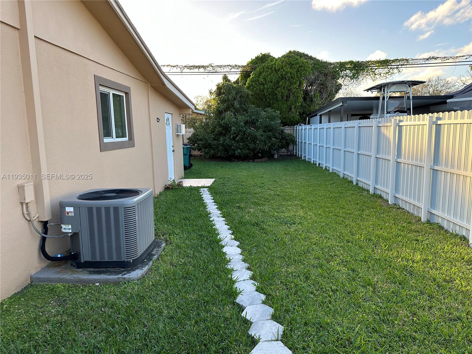 19360 Southwest 116th Avenue Miami, FL 33157 - Photo 14 of 17 a view of a backyard with white house and wooden fence