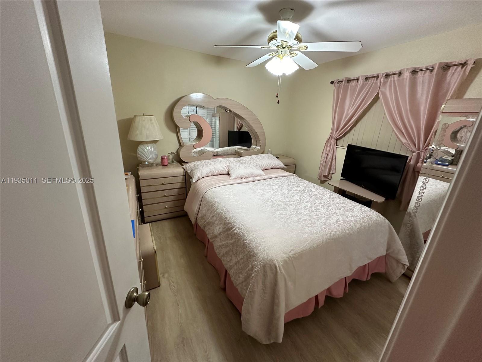 19360 Southwest 116th Avenue Miami, FL 33157 - Photo 3 of 17 a bedroom with a bed and a chandelier