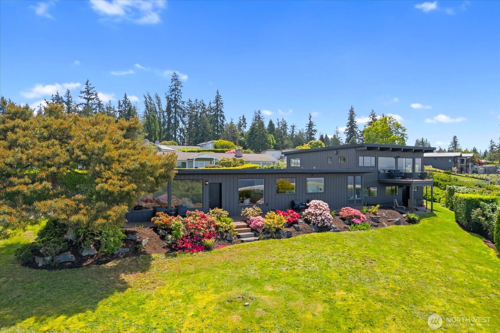 18220 Ridgefield Road Northwest Shoreline, WA 98177 - Photo 4 of 40 a view of a garage with plants and cars parked