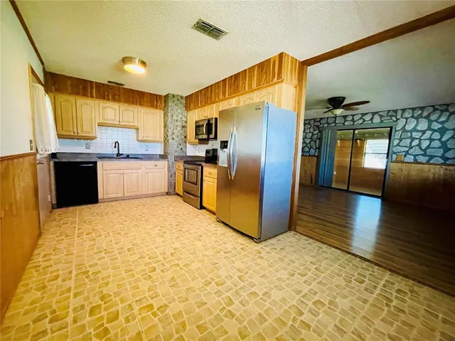a kitchen with stainless steel appliances granite countertop a refrigerator a stove and a sink with granite countertops