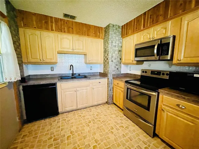a kitchen with stainless steel appliances a stove sink and microwave