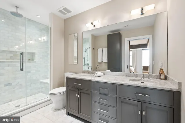 a bathroom with a granite countertop sink mirror and toilet