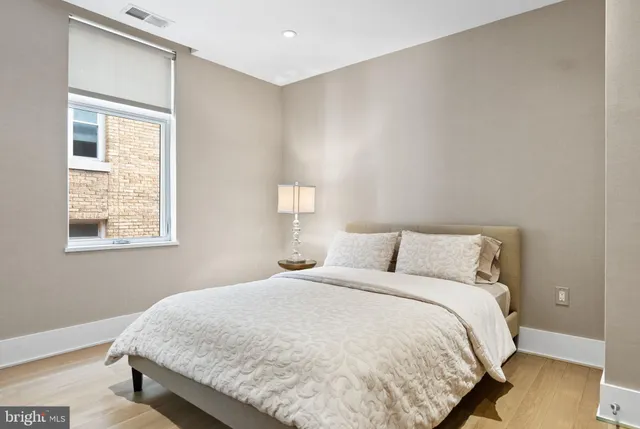 a large bed sitting in a bedroom next to a window