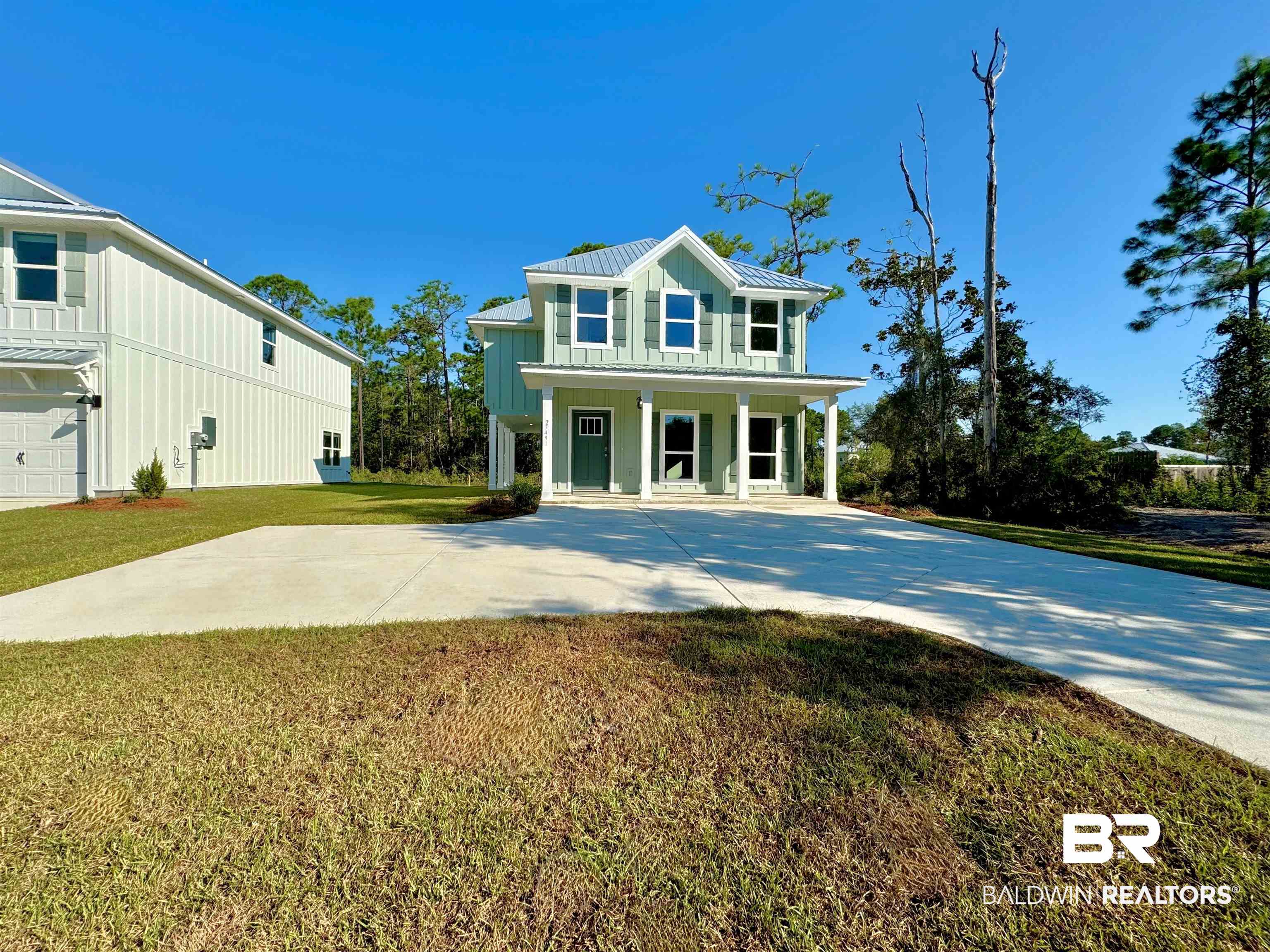 27491 Canal Road Orange Beach, AL 36561 - Photo 1 of 20 View of front of home with a front lawn, a porch, and a garage