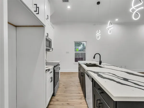 a kitchen with a sink and wooden floor