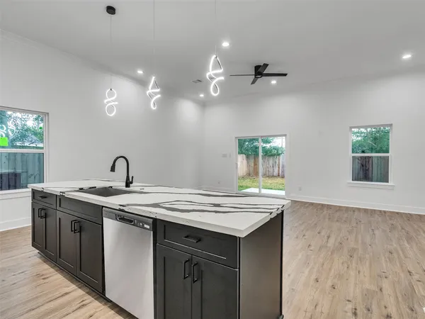 a kitchen with a sink cabinets and wooden floor