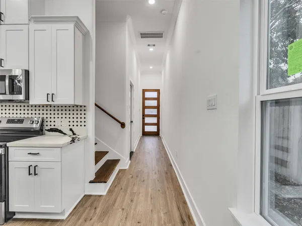 a view of a hallway with wooden floor and staircase