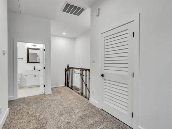 a view of a hallway with white walls and entryway