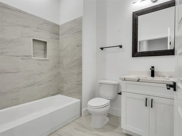 a bathroom with a toilet a sink a mirror and bathtub