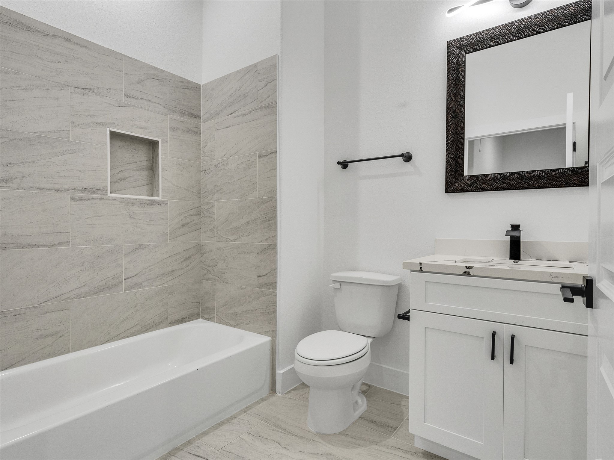 7358 Guadalcanal Road, Unit B Houston, TX 77033 - Photo 23 of 35 a bathroom with a toilet a sink a mirror and bathtub