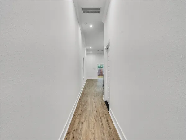 a view of a hallway with wooden floor