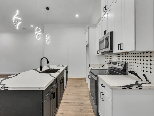 a kitchen with a sink stove and cabinets