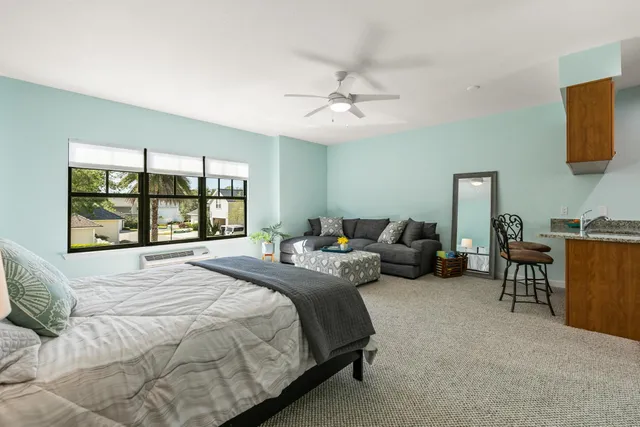 a bedroom with bed couch and window