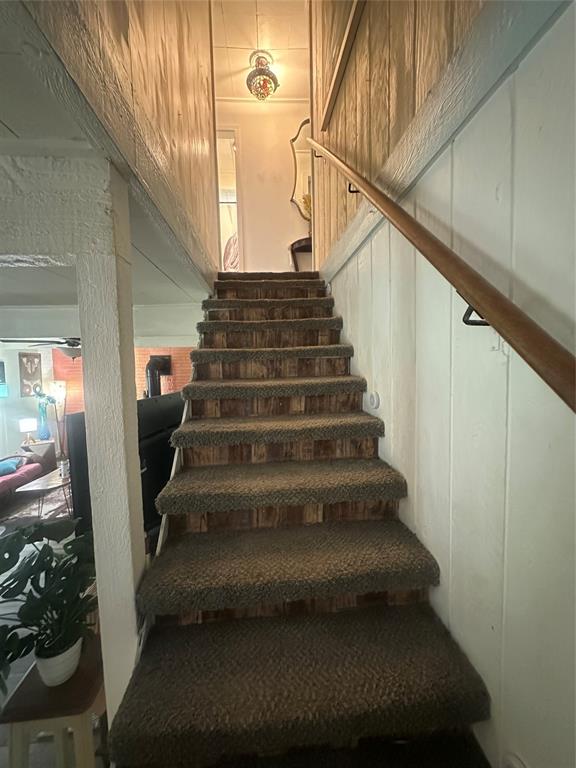 355 Spring Valley Street Gun Barrel City, TX 75156 - Photo 7 of 27 Carpeted staircase featuring wood-panel risers and a wood handrail