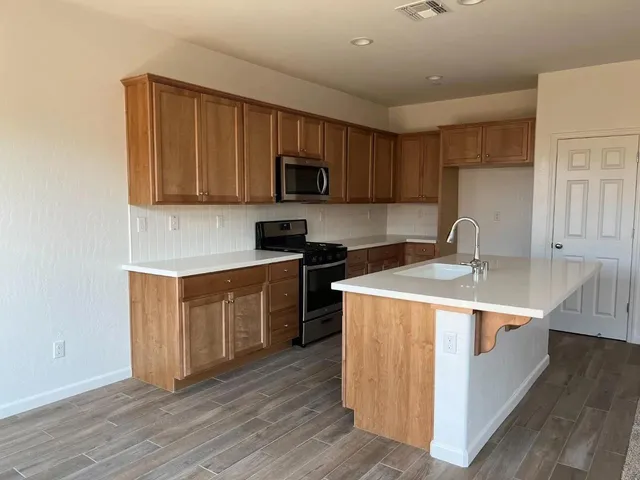 a kitchen with a sink and steel appliances