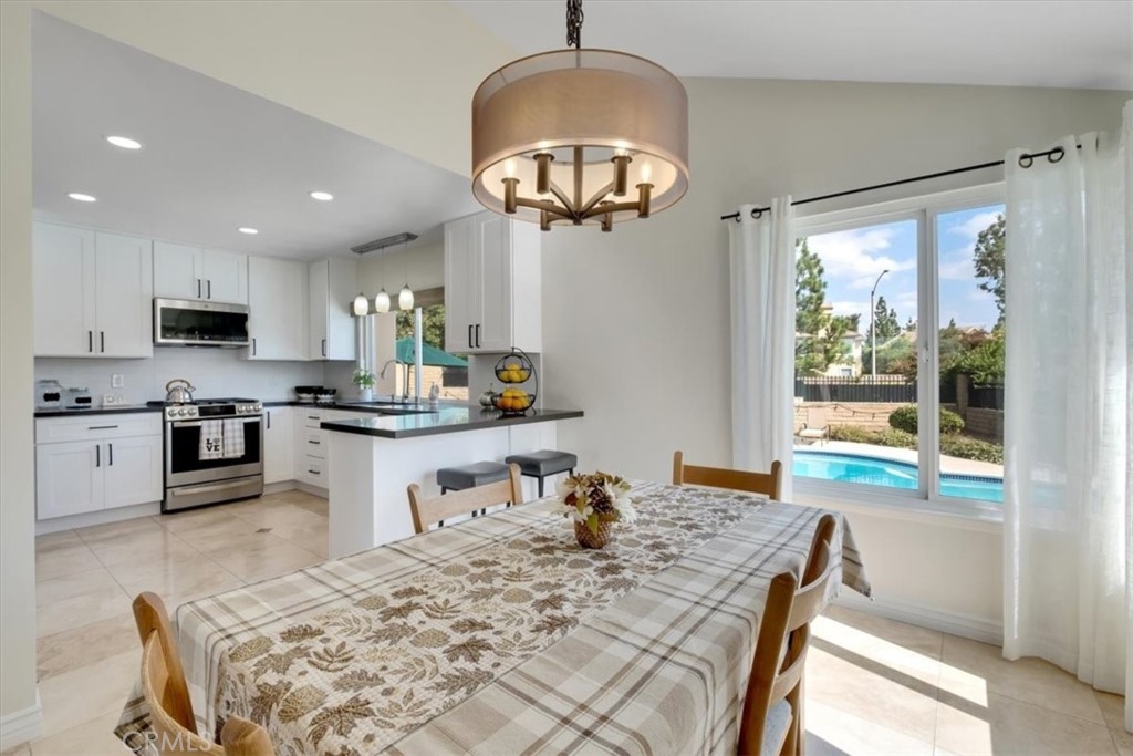 2232 Montague Circle Placentia, CA 92870 - Photo 6 of 36 a kitchen with a table chairs microwave and cabinets