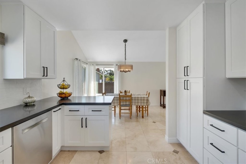 2232 Montague Circle Placentia, CA 92870 - Photo 7 of 36 a kitchen with white cabinets and dining table