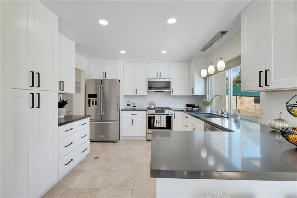 2232 Montague Circle Placentia, CA 92870 - Photo 9 of 36 a large kitchen with stainless steel appliances granite countertop a lot of counter space and wooden floor