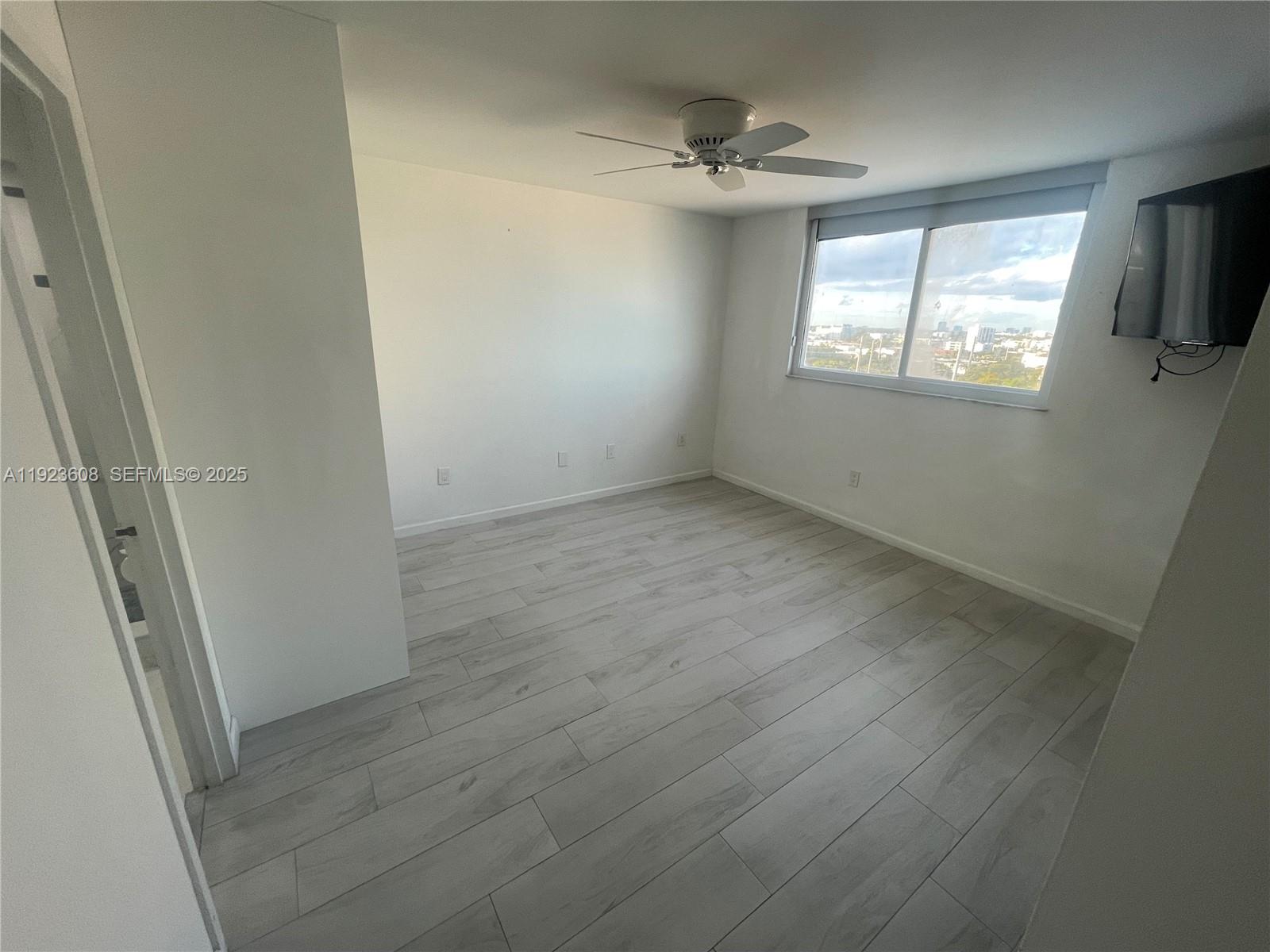 6969 Collins Avenue, Unit 903 Miami Beach, FL 33141 - Photo 7 of 18 en empty room with windows and ceiling fan