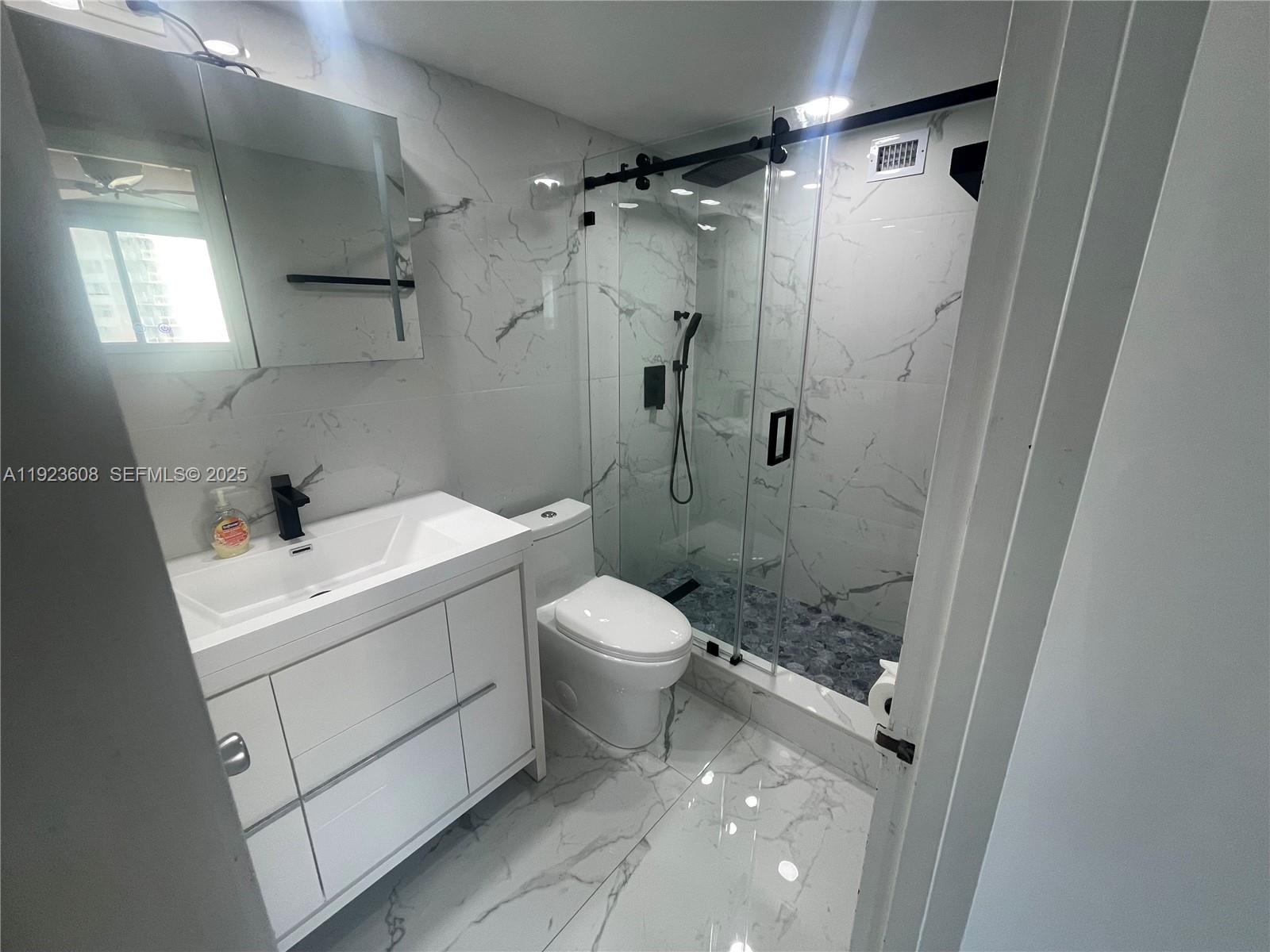 6969 Collins Avenue, Unit 903 Miami Beach, FL 33141 - Photo 10 of 18 a bathroom with a sink toilet and shower