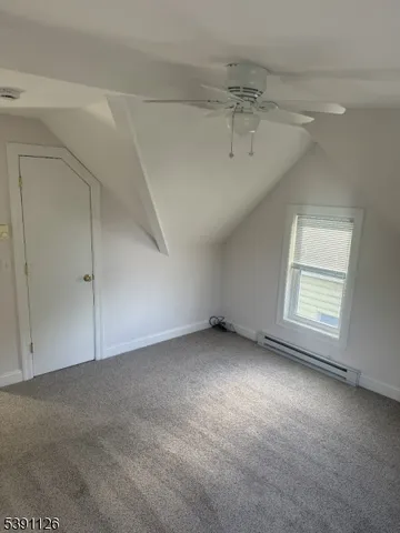 an empty room with a ceiling fan and window