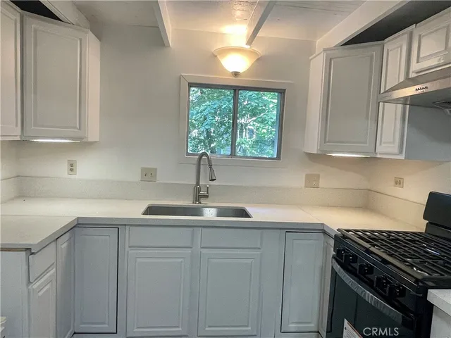 a kitchen with white cabinets and a stove top oven