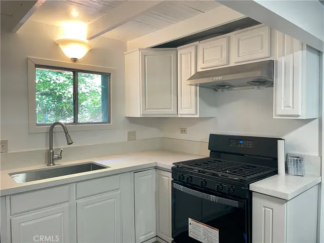 a kitchen with stainless steel appliances granite countertop a sink stove and cabinets