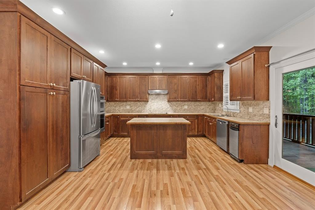 2239 Cross Roads Church Road Buchanan, GA 30113 - Photo 24 of 53 a kitchen with kitchen island granite countertop wooden floors stainless steel appliances a sink and cabinets