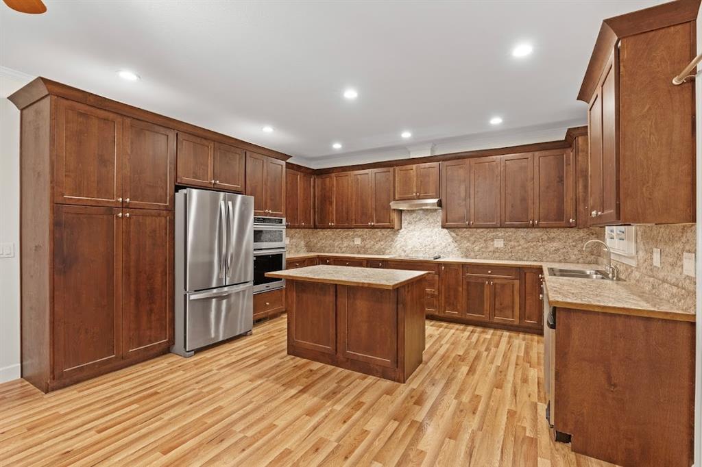 2239 Cross Roads Church Road Buchanan, GA 30113 - Photo 25 of 53 a kitchen with granite countertop wooden cabinets a refrigerator and a sink