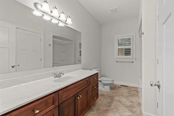 a white toilet and tub sitting next to a window