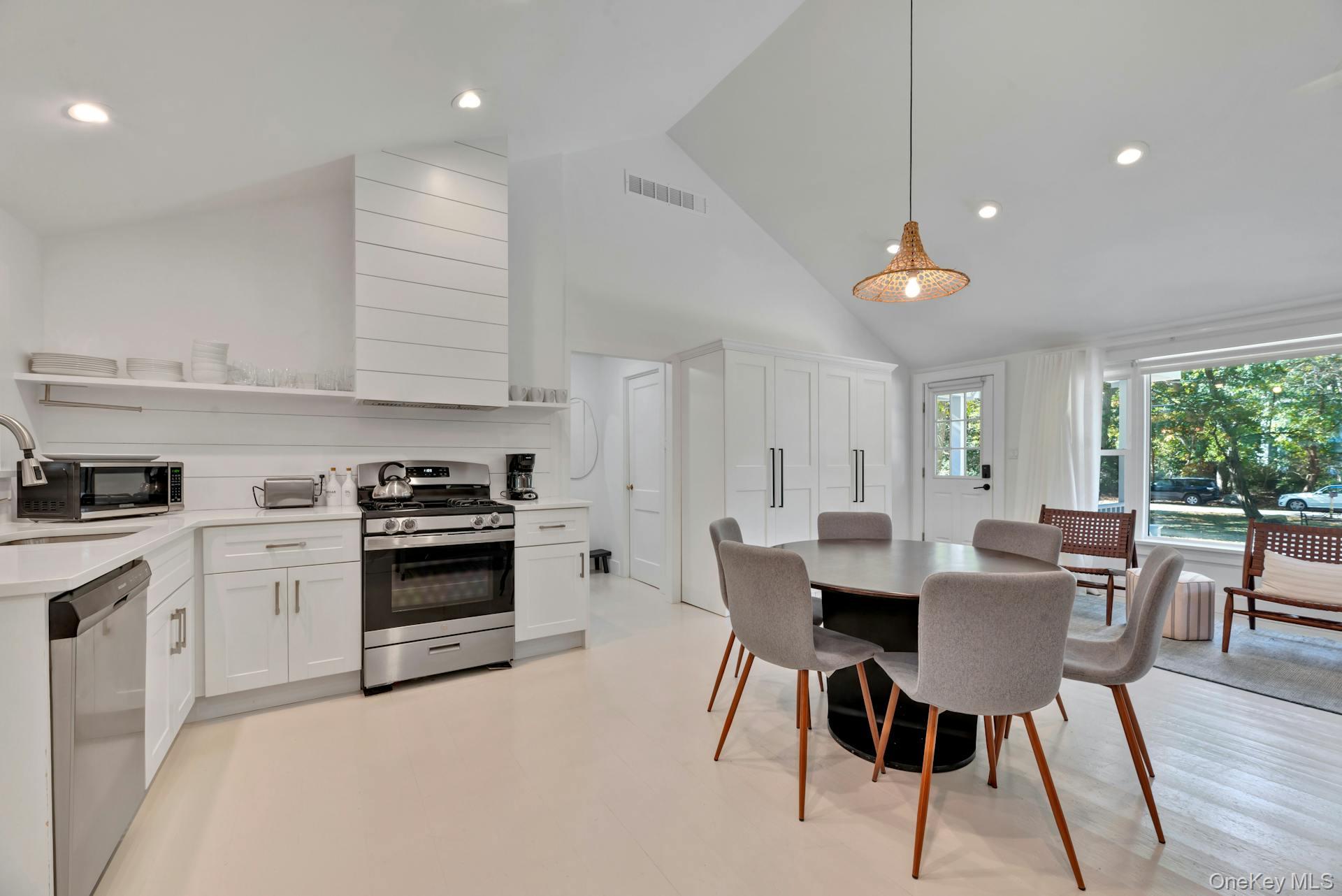 3670 Rocky Point Road East Marion, NY 11939 - Photo 5 of 27 a kitchen with stainless steel appliances a table chairs and a refrigerator