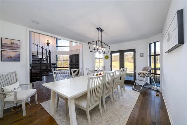 a living room with furniture a large window wooden floor and a flat screen tv