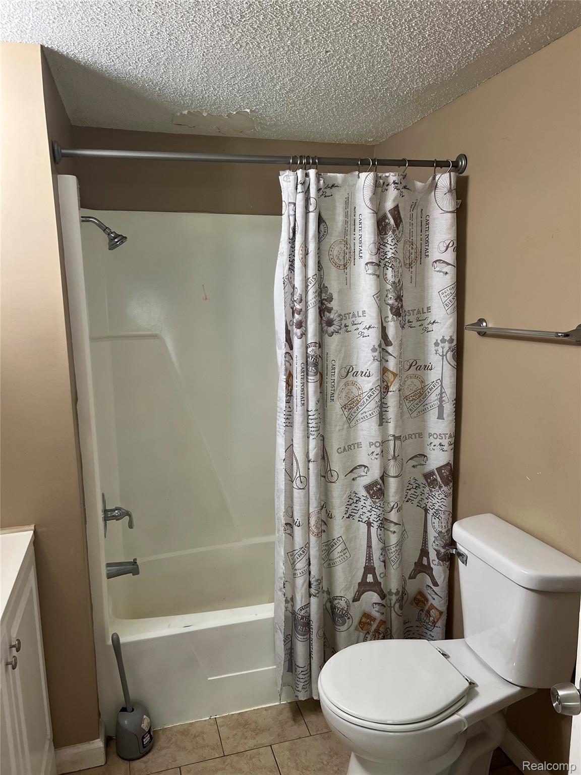 35945 Herman Street Romulus, MI 48174 - Photo 20 of 26 Bathroom with shower / tub combo with curtain, light tile patterned floors, a textured ceiling, and vanity