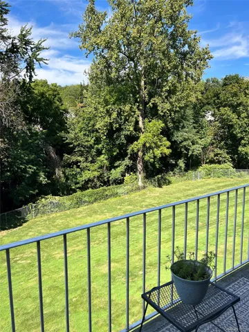 a view of balcony with two chairs and a potted plant