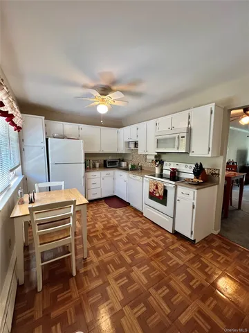 a kitchen with granite countertop a sink a stove and cabinets