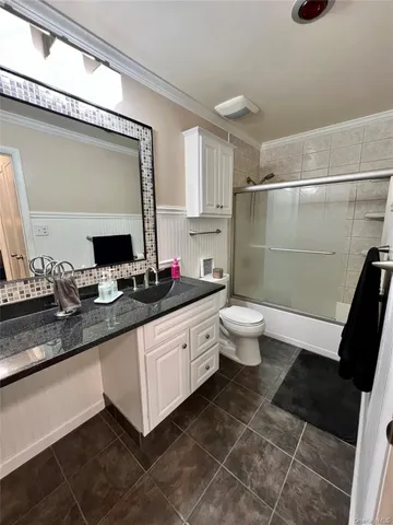 a kitchen with stainless steel appliances a stove top oven a sink a refrigerator and white cabinets