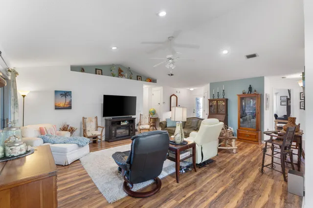 a living room with furniture and a flat screen tv with wooden floor