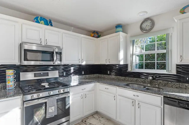 a kitchen with a sink cabinets and stainless steel appliances