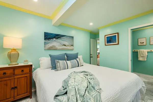 a bedroom with a bed and a lamp on dresser