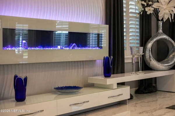 a living room with patio furniture and floor to ceiling windows